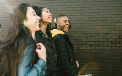 Illustrasjonsbilde av tre videregåendeelever som går ved siden av hverandre ute. Foto: Istock.
