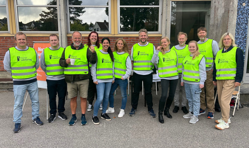 Bilde av streikende lektorlagsmedlemmer ved Frederik II vgs. i Fredrikstad som har på seg gule streikevester. Bildet er fra fjerde uttaks første streikedag 12. september 2022. Foto: Norsk Lektorlag