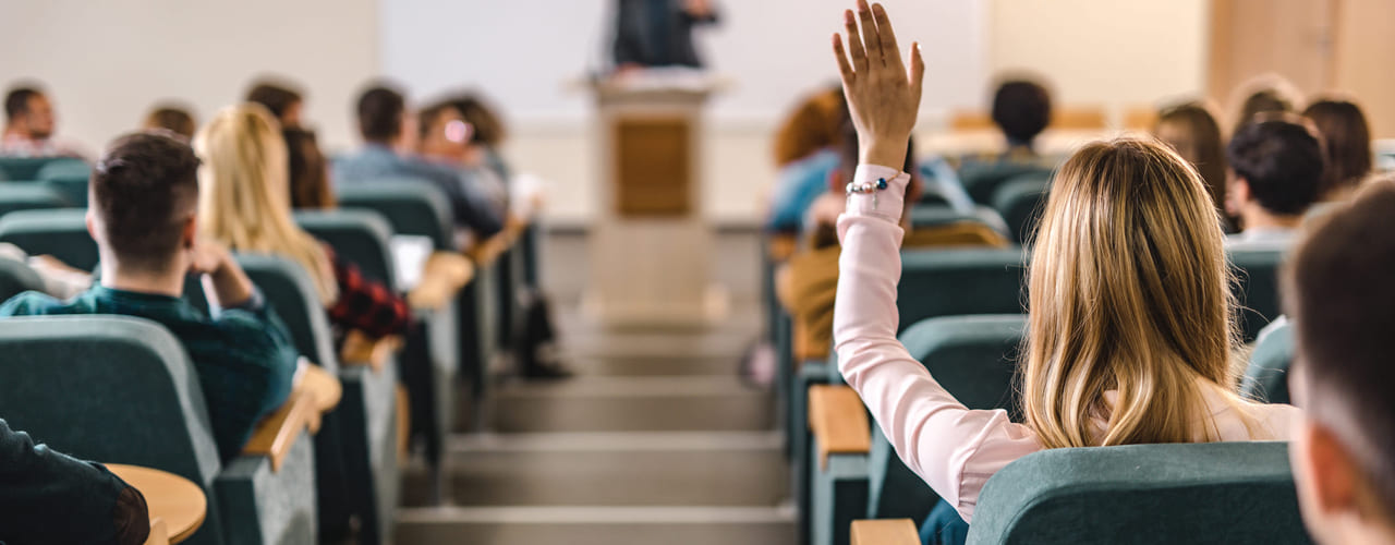Mennesker sitter i en forelesningssal. Bilde.