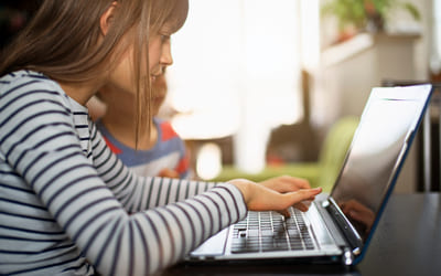 Elev sitter foran laptop. Bilde.