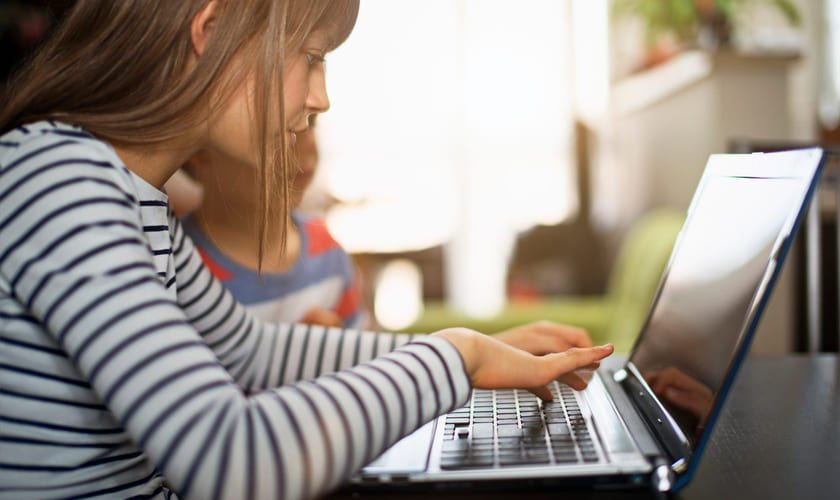 Elev sitter foran laptop. Bilde.