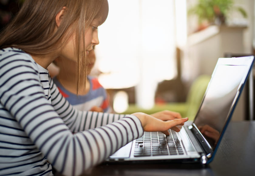 Elev sitter foran laptop. Bilde.