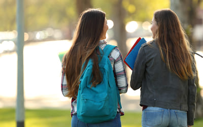 To tenåringsjenter på vei til skolen. Bilde.