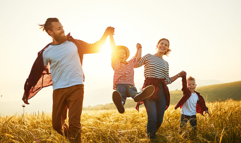 Foreldre med to barn leker i en kornåker. Bilde.