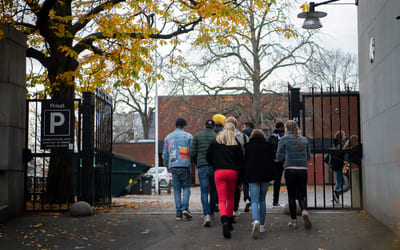 En gruppe videregåendeelever går inn på skolens område. Bilde.