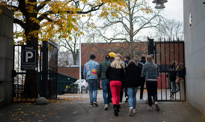 En gruppe videregåendeelever går inn på skolens område. Bilde.