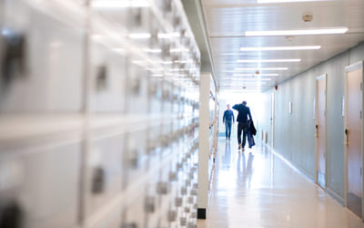 En lærer går i en gang på en skole. Bilde.