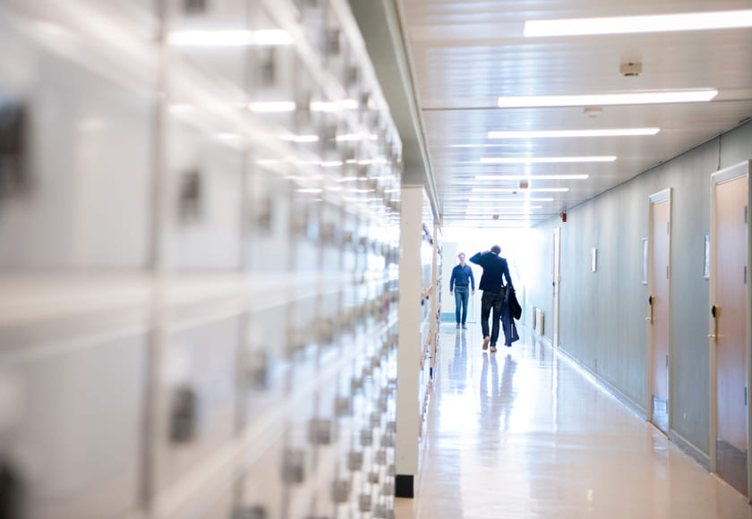 En lærer går i en gang på en skole. Bilde.