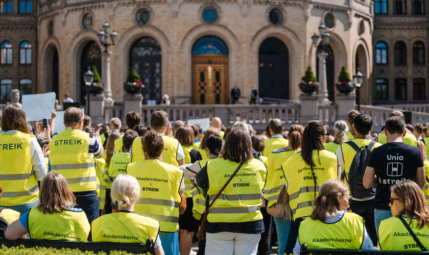 Folk med streikevest utenfor Stortinget våren 2024. Bilde.