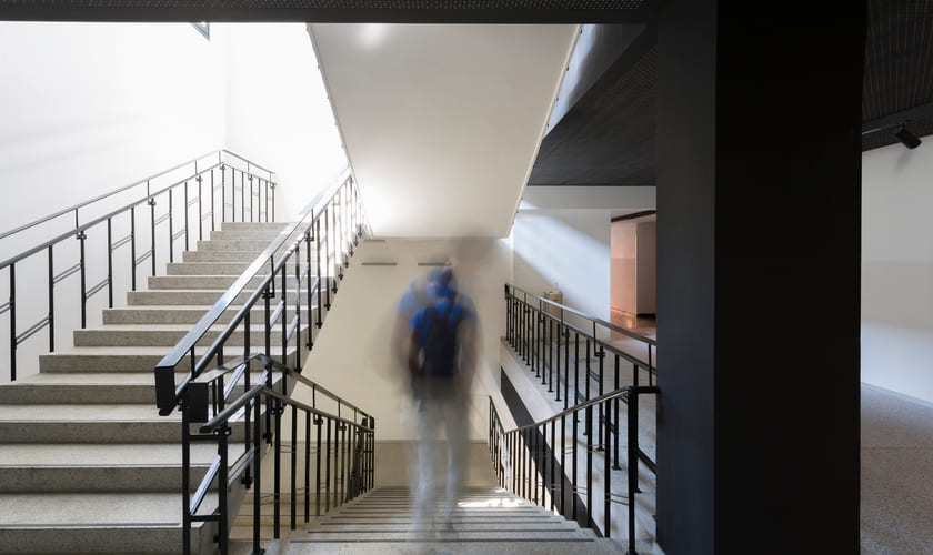 En elev går ned en trapp i en skole. Bilde.