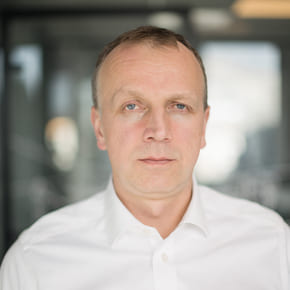 En mann i hvit skjorte stirrer på kameraet på et kontor