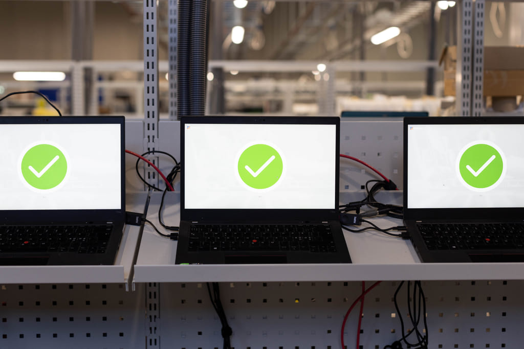 Laptoper som klargjøres i et fabrikklokale.