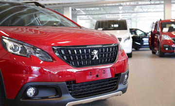 Fronten på en rød bil av merket Peugeot