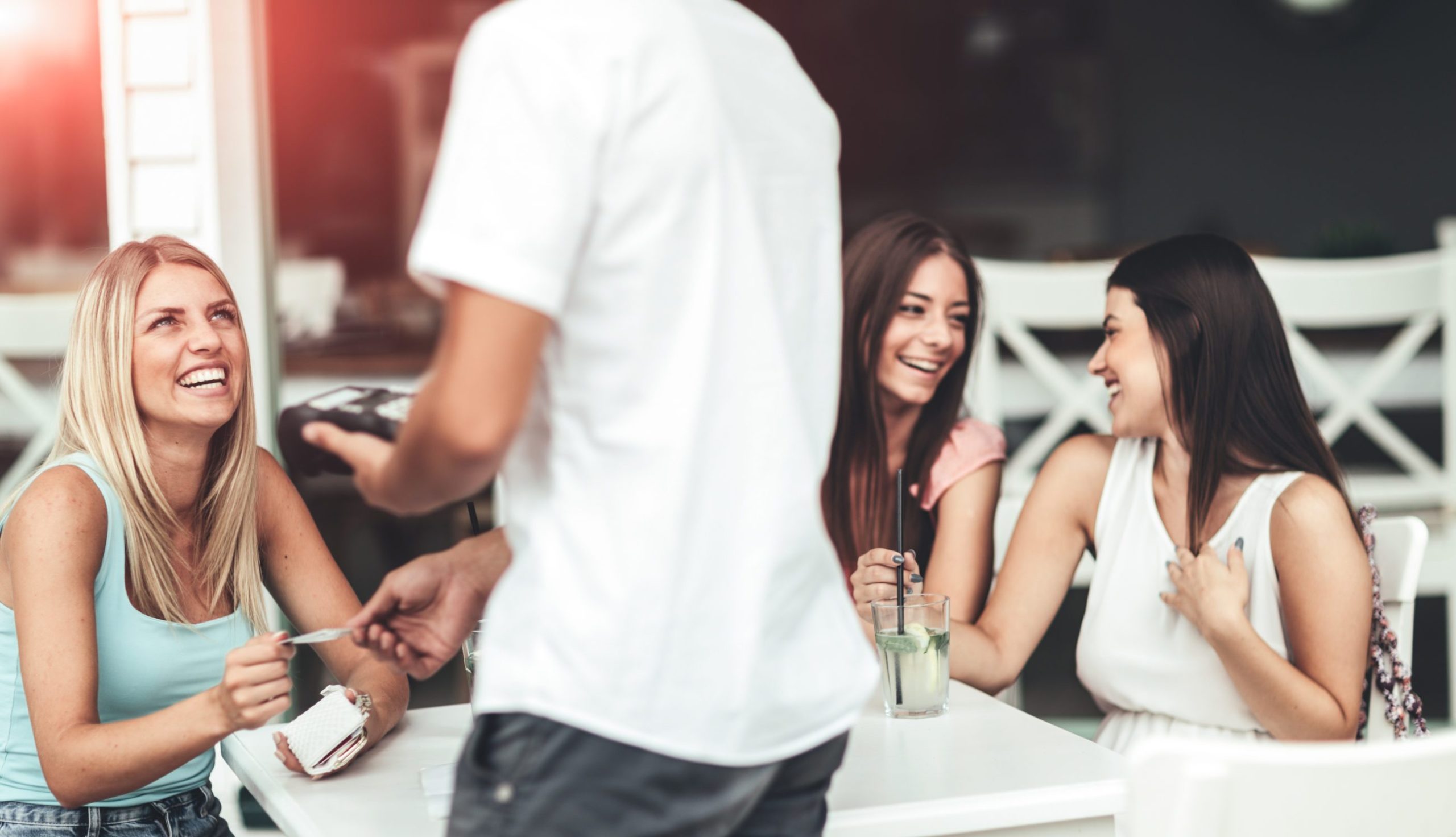 kvinne som gir kredittkortet sitt til kelneren på en restaurant