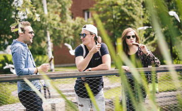 tre unge mennesker spiser is og nyter ferielivet