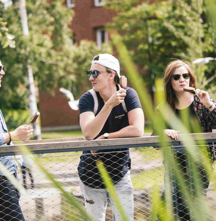 tre unge mennesker spiser is og nyter ferielivet