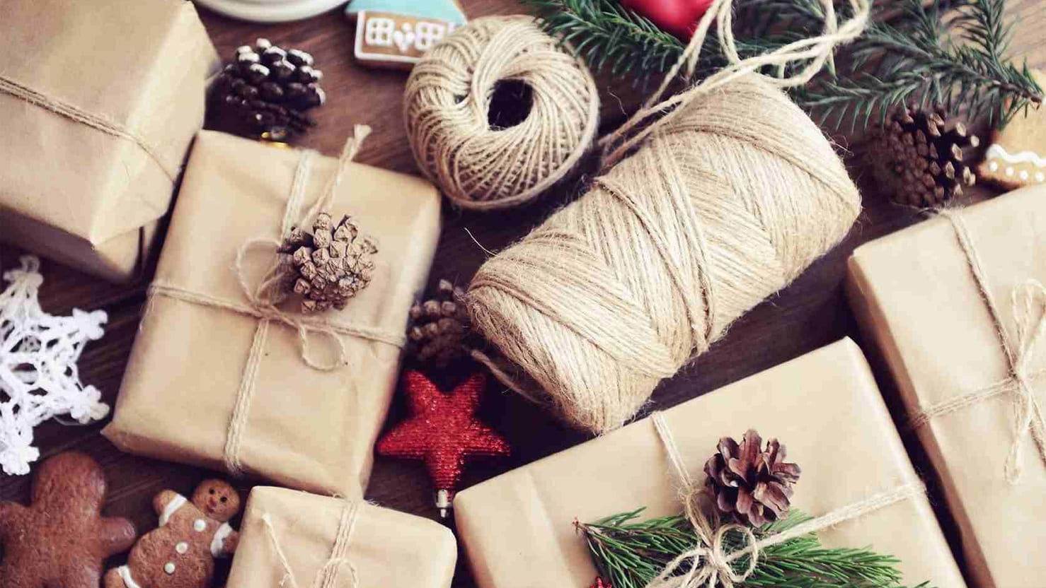 Julegaver som ligger ferdig innpakket i gavepapir med tau og pynt