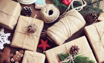 Julegaver som ligger ferdig innpakket i gavepapir med tau og pynt