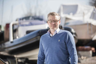 Båtentusiast står foran en RIB som er tatt opp på land