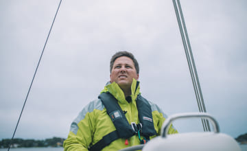 mann som styrer en seilbåt