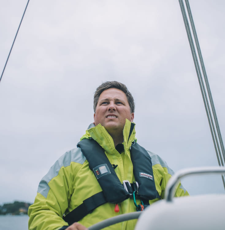 mann som styrer en seilbåt