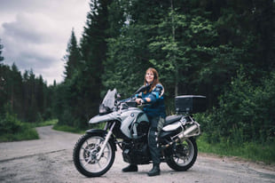 Kvinne sitter på en adventure-MC