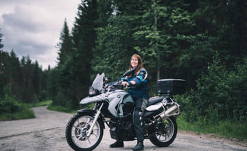 Kvinne sitter på en adventure-MC