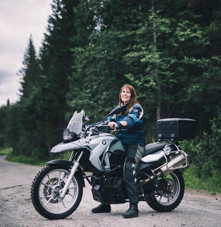 Kvinne sitter på en adventure-MC