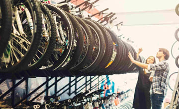 to som ser på sykler i en sykkelbutikk