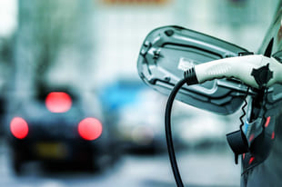 Elbillader som står koblet til en elbil