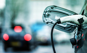 Elbillader som står koblet til en elbil