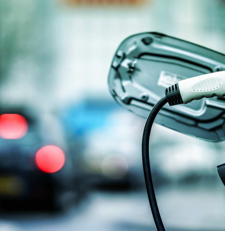 Elbillader som står koblet til en elbil