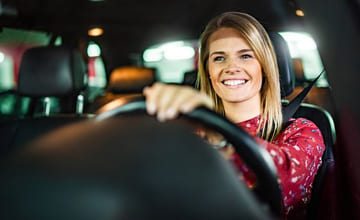 Kvinne bak rattet i en bil
