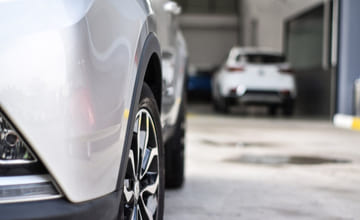 Utsnitt av panser og det ene hjulet på en bruktbil