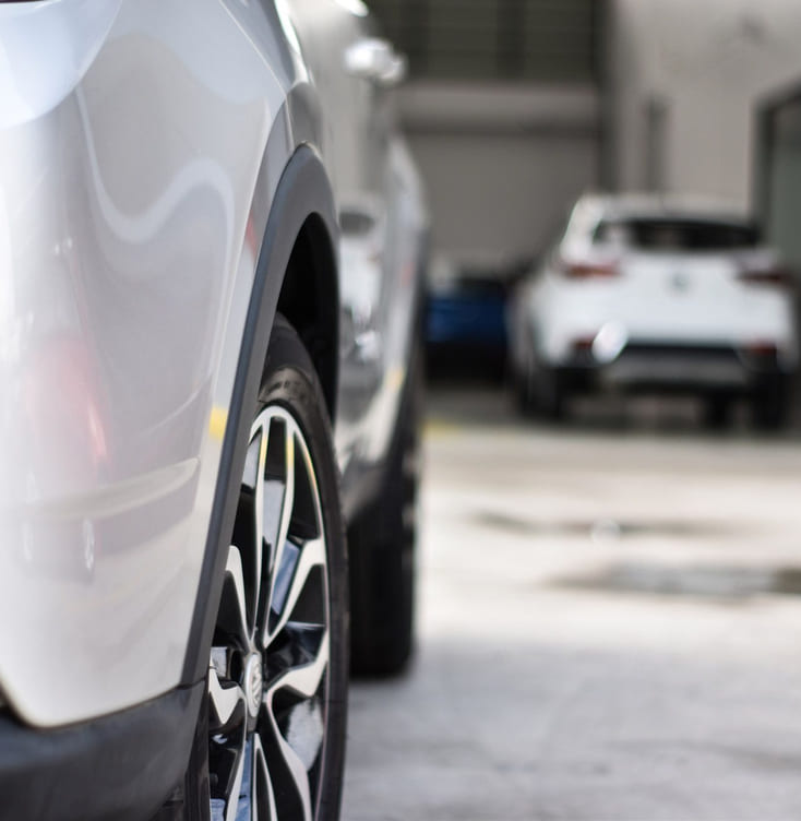 Utsnitt av panser og det ene hjulet på en bruktbil