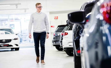 Mann som ser på bruktbiler hos forhandler