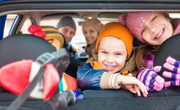 Glad familie i fullpakket stasjonsvogn