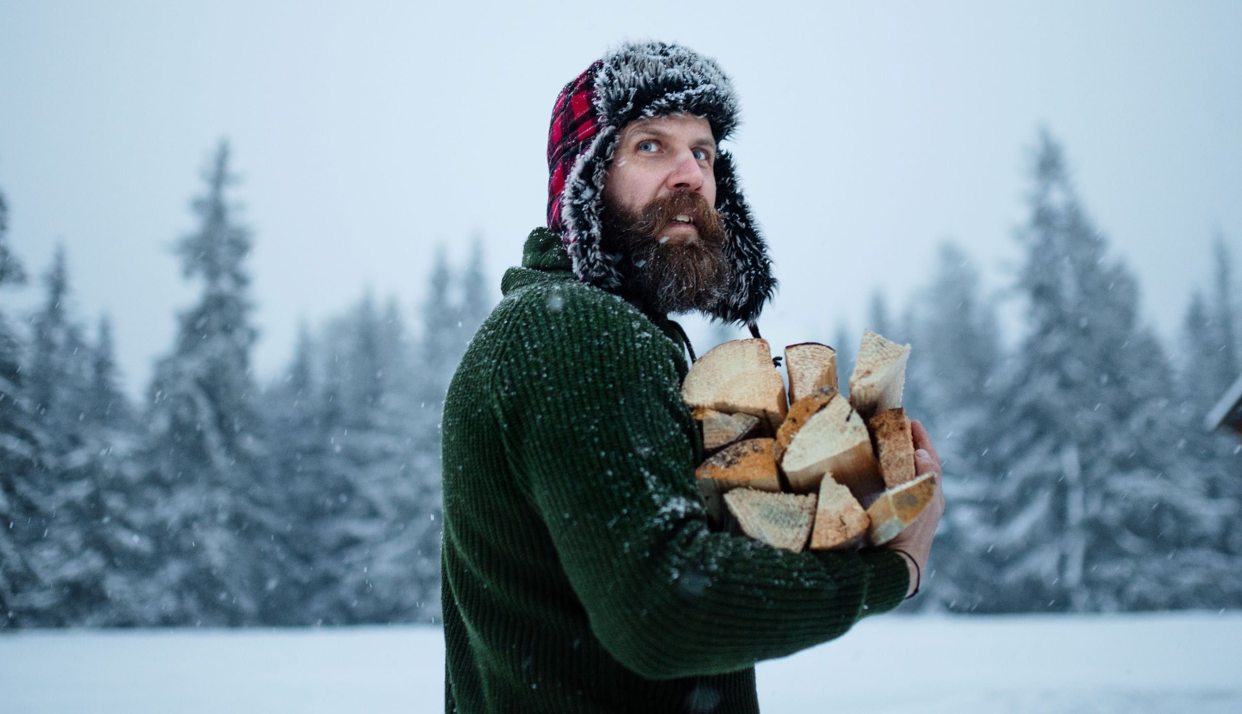 mann med rutete lue bærer ved