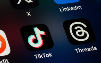 Foto av mobilskjerm med logoer for flere apper med TikTok i sentrum