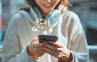 Foto av ung jente som smiler og sender meldinger på en smarttelefon, illustrert med snakkebobler i bildet